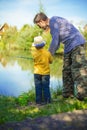 Little boy is engaged in fishing in a pond. Child with a dairy i Royalty Free Stock Photo