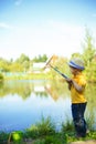 Little boy is engaged in fishing in a pond. Child with a dairy i Royalty Free Stock Photo