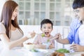 Little boy  enjoy eating food with father and mother. Happy Asian  family having dinner at home Royalty Free Stock Photo