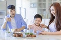 Little boy  enjoy eating food with father and mother. Happy Asian  family having dinner at home Royalty Free Stock Photo