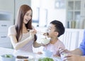 Little boy  enjoy eating food with father and mother. Happy Asian  family having dinner at home Royalty Free Stock Photo