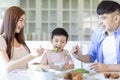 Little boy  enjoy eating food with father and mother. Happy Asian  family having dinner at home Royalty Free Stock Photo