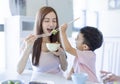 Little boy  enjoy eating food with  mother. Happy Asian  family having dinner at home Royalty Free Stock Photo