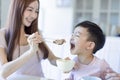 Little boy  enjoy eating food with  mother. Happy Asian  family having dinner at home Royalty Free Stock Photo