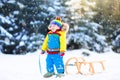 Little boy enjoying a sleigh ride. Child sledding. Toddler kid riding a sledge. Children play outdoors in snow. Kids sled in the Royalty Free Stock Photo