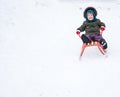 Little boy enjoying a sleigh ride. Child sledding. Toddler kid riding a sledge. Royalty Free Stock Photo