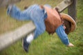 Little boy falling over a fence playing cowboys Royalty Free Stock Photo