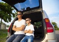 Little boy and father sitting on their car Royalty Free Stock Photo