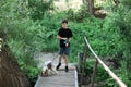 Little boy and favorite companion dog coker spaniel friend Charles walking in garden, trees, greenery on wooden bridge.