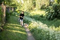 Little boy and favorite companion dog coker spaniel friend walking in garden, trees, flowers, street. Light day outdoor