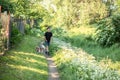 Little boy and favorite companion dog coker spaniel friend walking in garden, trees, greenery, street. Light day outdoor