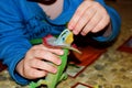 A little boy is feeding a toy dinosaur. A child plays with his toy dinosaur.