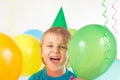 Little boy in festive cap with holiday balls and streamer Royalty Free Stock Photo