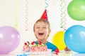 Little boy in festive hat with festive cake and balloons Royalty Free Stock Photo