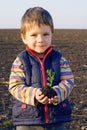 Little boy on field holding the plan Royalty Free Stock Photo