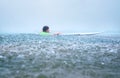Little boy first step surfer try to stand up on board under tropical rain Royalty Free Stock Photo