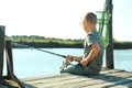 Little boy fishing alone on sunny day.