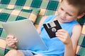 Little boy with floppy disk and tablet pc Royalty Free Stock Photo