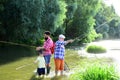 Little boy fly fishing on a lake with his father and grandfather. Man with his son and father on river fishing with Royalty Free Stock Photo