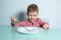 Child sits at the table and eats food Royalty Free Stock Photo