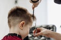 Close-up of woman hands grooming kid boy hair in barber shop Royalty Free Stock Photo