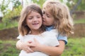 Little boy and girl best friends hugging. Kids kissing each other with love at summer park. Happy kids couple in love