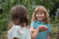 Little boy and girl best friends walking in park. Kids kissing each other with love at summer park. Kids friends playing