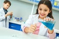Little kids learning chemistry in school laboratory pouring liquid Royalty Free Stock Photo
