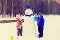 Little boy and girl play with snowman in winter nature Royalty Free Stock Photo