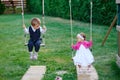 Little boy and girl ride on a swing at the playground in the park Royalty Free Stock Photo