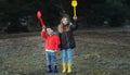 A little boy and girl in rubber boots are walking through the forest and holding shovels. Royalty Free Stock Photo
