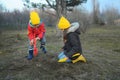 A little boy and girl in rubber boots are walking through the forest and holding shovels. Royalty Free Stock Photo