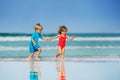 Little boy and girl run on sand beach holding hands Royalty Free Stock Photo