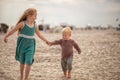 little boy and girl run in the summer along the seashore, holding hands. Brother and sister in natural clothes. Tourism Royalty Free Stock Photo