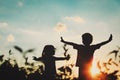 Little boy and girl silhouettes play at sunset