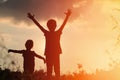 Little boy and girl silhouettes play at sunset