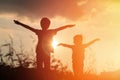 Little boy and girl silhouettes play at sunset