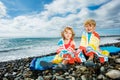 Little boy and girl sit wrapped in beach towel over the sea Royalty Free Stock Photo