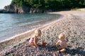 Little boy and girl are sitting on the beach and sorting through the pebbles Royalty Free Stock Photo