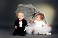 Little boy and girl sitting under umbrella Royalty Free Stock Photo