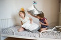 Little boy and girl staged a pillow fight on the bed in the bedroom. Royalty Free Stock Photo