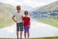 Little boy and girl standing holding hands on the bank of a lake Royalty Free Stock Photo