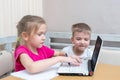 Little boy and girl study online at home. Cute little girl student shows how to do homework to her brother Royalty Free Stock Photo