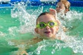 Little boy and girl swimming in swimming pool on sunny summer day Royalty Free Stock Photo