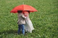 Little boy and girl under red umbrella Royalty Free Stock Photo