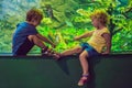 Little Boy and girl watching tropical coral fish in large sea life tank. Kids at the zoo aquarium Royalty Free Stock Photo