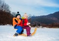 Little boy and girl in winter outfit siting on the sledge Royalty Free Stock Photo