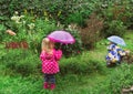 Little boy and girl working in the garden unter the rain Royalty Free Stock Photo