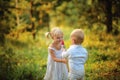 Little boy gives a flower to a little girl in the wood Royalty Free Stock Photo