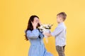 A little boy gives his mother a bouquet of flowers. A beautiful woman with her charming son. March 8 Royalty Free Stock Photo